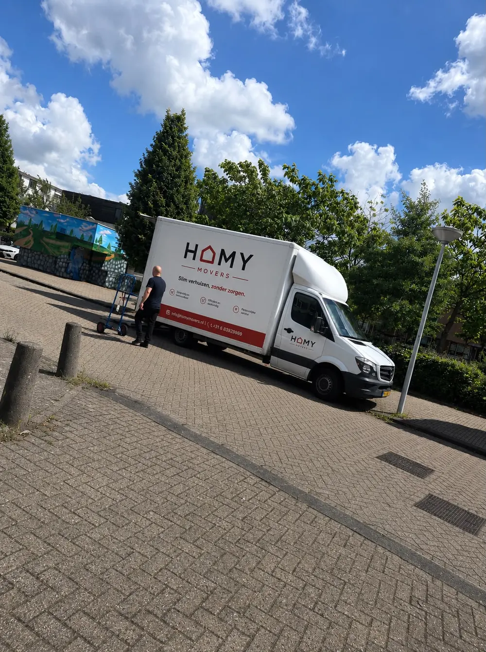 HomyMovers verhuiswagen geparkeerd in de zon